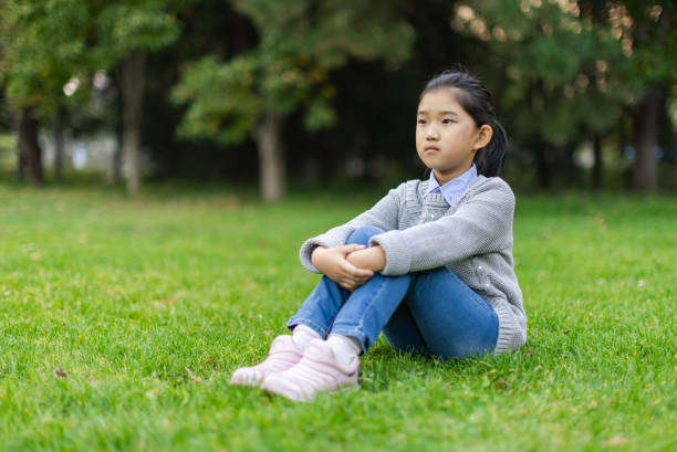istock Little Girl Sitting on Grass 1482385998