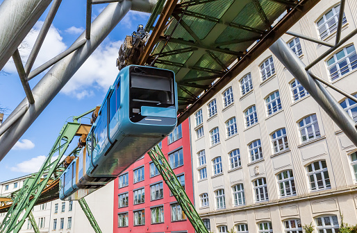 Panorama of the suspended monorail train in front of historic buildings in Wuppertal