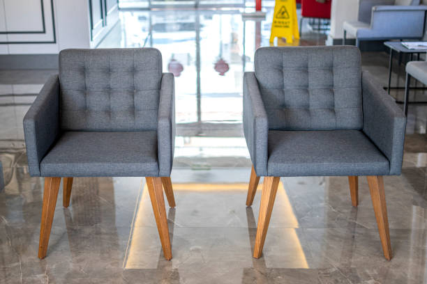 Three chairs of different colors in the interior of an empty gray room