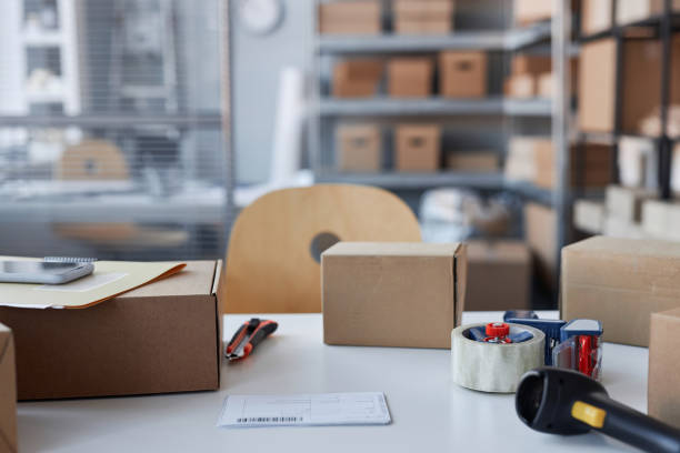 istock Several packed parcels, knife and cellotape on desk in storage room 1482392196