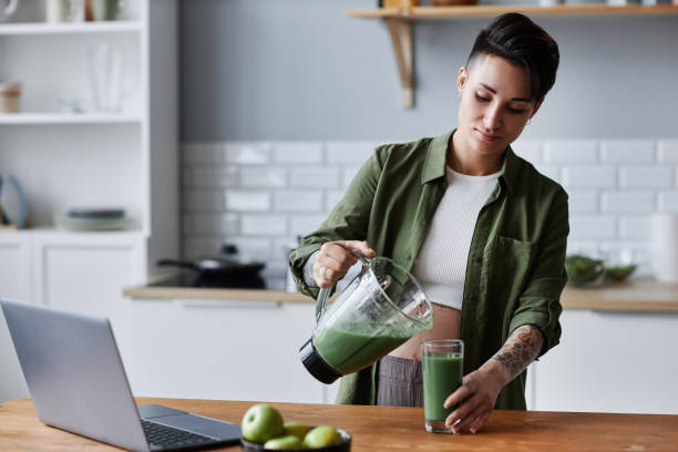 istock Pregnant young woman making smoothie for breakfast in kitchen setting 1482392240