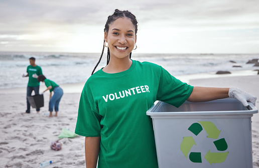 Cleaning, recycle and portrait of black woman at beach for plastic, environment or earth day. Recycling, sustainability and climate change with volunteer and trash for pollution and eco friendly