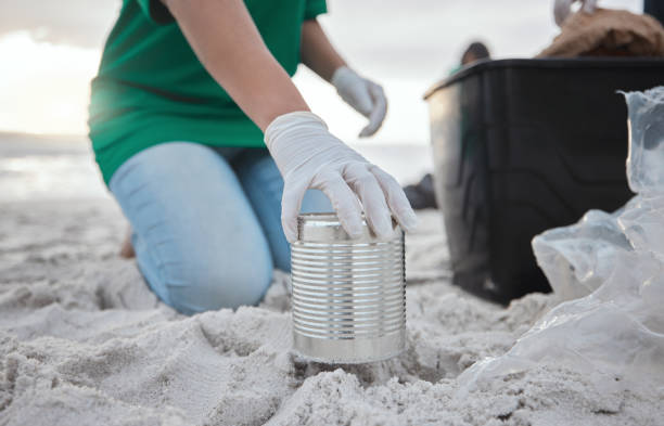 Recycle, volunteer hand cleaning beach and can in sand, picking up dirt at ocean on earth day. Community service, sustainability and environmental charity, people pick up trash for future of planet. reciclar, voluntario limpieza manual de la playa y latas en la arena, recogiendo la suciedad en el océano en el día de la tierra. servicio comunitario, sostenibilidad y caridad ambiental, las personas recogen basura para el futuro del planeta.