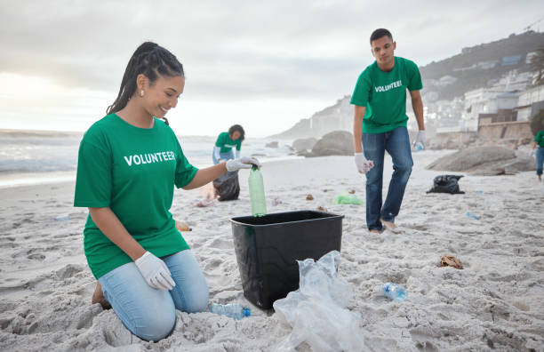 istock Teamwork, cleaning and recycling with people on beach for sustainability, environment and eco friendly. Climate change, earth day and nature with volunteer and plastic for help, energy and pollution 1482392569