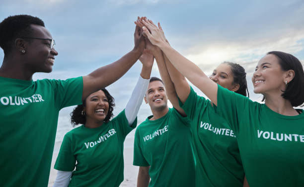 istock Teamwork, high five and volunteer with people on beach for sustainability, environment and climate change. Charity, earth day and community with friends for support, diversity and pollution awareness 1482392602