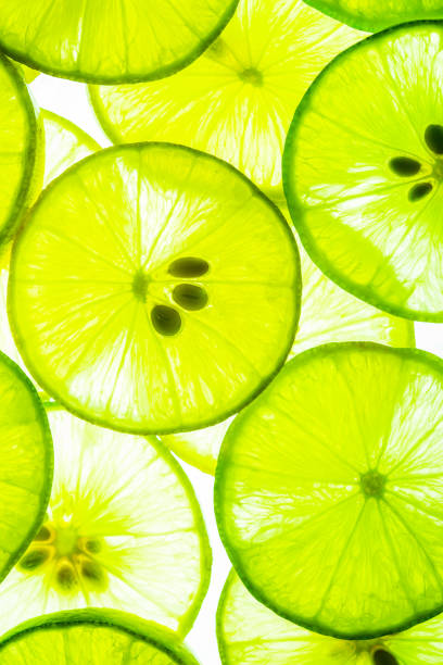 マクロレモンの背景、マクロライム、レモンとグリーンライムがスライスを重ねたクローズアップ背景、マクロレモンのテクスチャ - lemon textured peel portion ストックフォトと画像