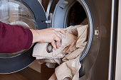 Close-up of woman taking clothes out of washing machine