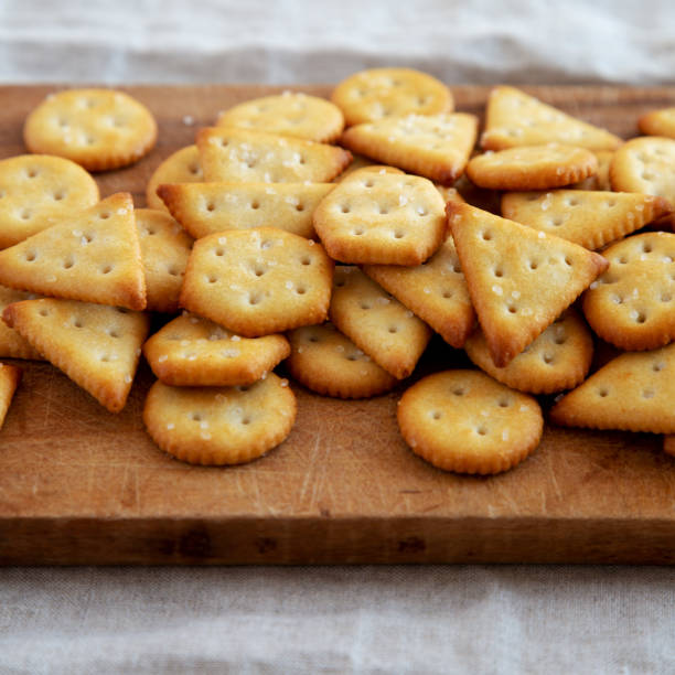 istock Homemade Salty Crackers on a Rustic Wooden Board, side view. Close-up. 1482405700