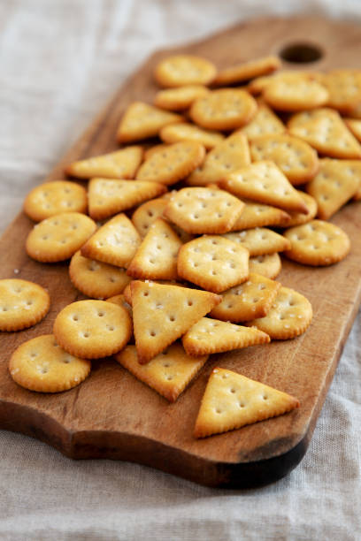 istock Homemade Salty Crackers on a Rustic Wooden Board, side view. Close-up. 1482405710