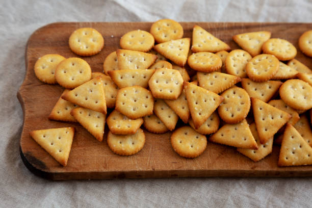 istock Homemade Salty Crackers on a Rustic Wooden Board, low angle view. 1482406723