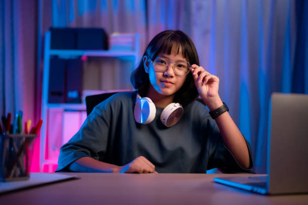 istock Asian girl playing game in night room looking at camera smiling 1482406830