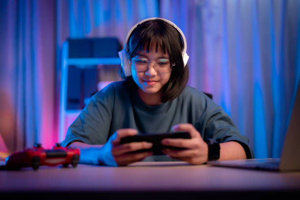 istock Asian girl playing game on phone at night having fun 1482406846