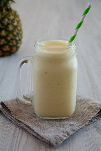 istock Homemade Pineapple Mango Banana Smoothie in a Glass Jar, side view. 1482410384