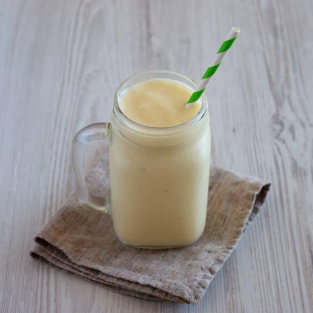 istock Homemade Pineapple Mango Banana Smoothie in a Glass Jar, side view. 1482410405