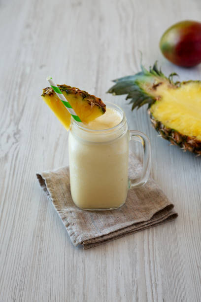 istock Homemade Pineapple Mango Banana Smoothie in a Glass Jar, low angle view. 1482410485