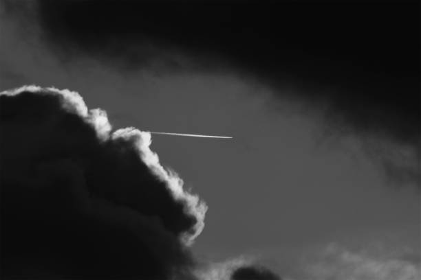 Image of plan breaking through the cloudscape, high in the sky.