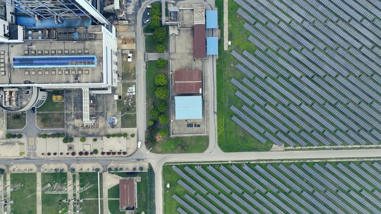Aerial view of solar panels farm field near factory