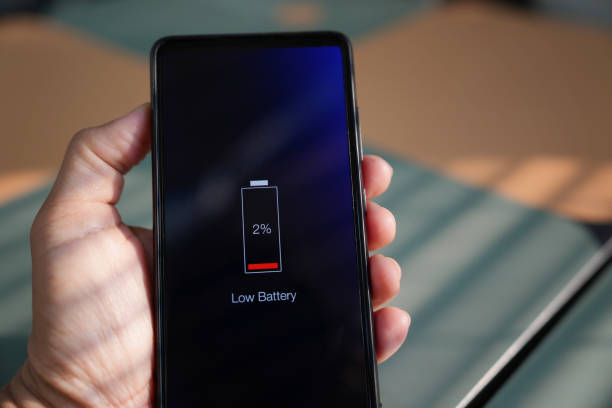 istock Man holding his smartphone showing low battery level on screen 1482413876