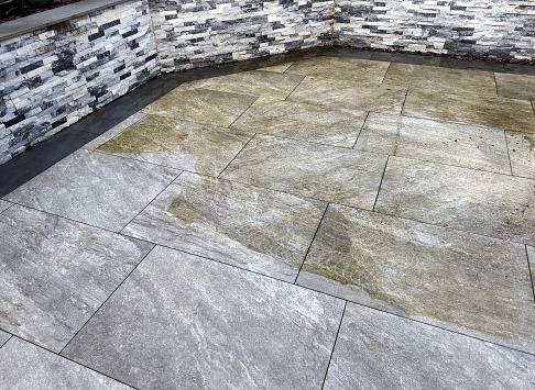 Contrast between clean and dirty parts of a garden patio after being pressure washed. No people.