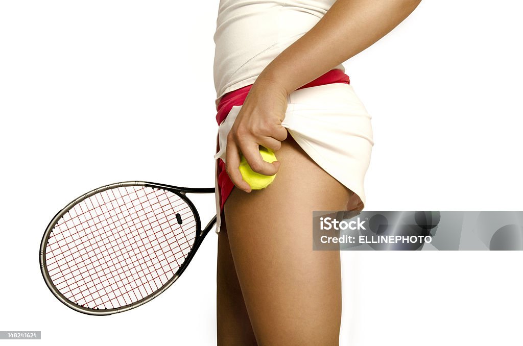 Woman Tennis Player Tennis player is getting ready to serve. She is in a white&pink skirt and putting her extra ball under the skirt, racket is in her right hand. Tennis Outfit Stock Photo