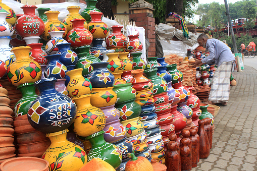 A seller decorated clay pots with colors in preparation for Bengali New Year. Bengali New Year celebration venue is decorated with such materials. Sylhet, Bangladesh, 8 April 2018.