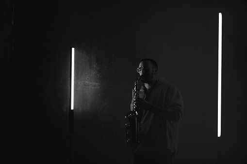 Male musician playing saxophone in studio.