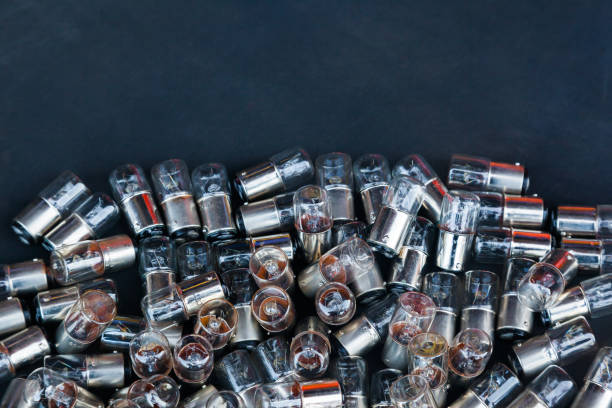 istock Many small incandescent bulbs lie in a heap on a black background, close-up. 1482425363