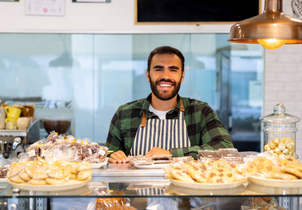 istock Happy waiter smiling behind the counter while working at a coffee shop 1482426172