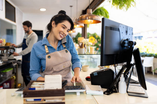 camarera feliz tomando un pedido de entrega por teléfono en una cafetería - pequeña empresa fotografías e imágenes de stock