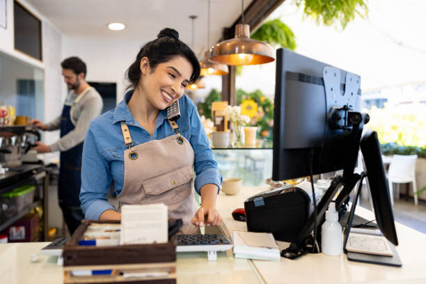 happy waitress taking a delivery order on the phone at a coffee shop - family business stockfoto's en -beelden