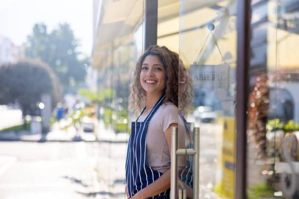 istock Happy waitress opening the doors of a cafe 1482426224