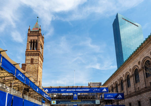 Boston, Massachusetts, USA - April 14, 2023: Skyward view of the viewing stands and banners at the 127th Boston Marathon finish line across Boylston Street near Copley Square. The marathon is always run on the Patriots Day holiday, April 17th for 2023. On the righthand side is the Boston Public Lbrary McKim building (c 1895) and beyond it is the John Hancock skyscraper (c. 1976), now simply named 200 Clarendon Street. On the lefthand side is the tower of the Old South Church (c. 1873).