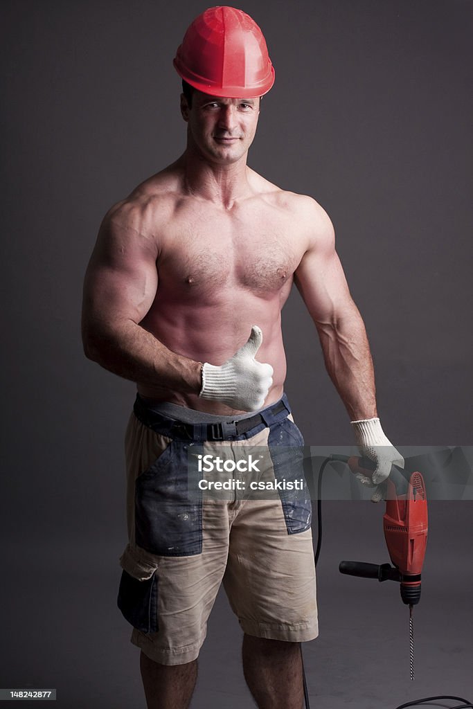 muscular construction worker muscular construction worker with drill Muscular Build Stock Photo