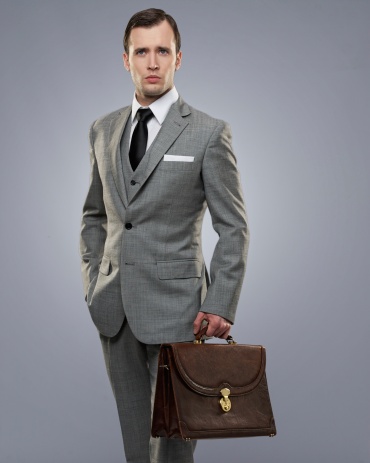 Businessman with a briefcase isolated on grey.