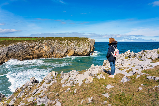 Woman hiking high on the cliffs of northern Spain, Asturias