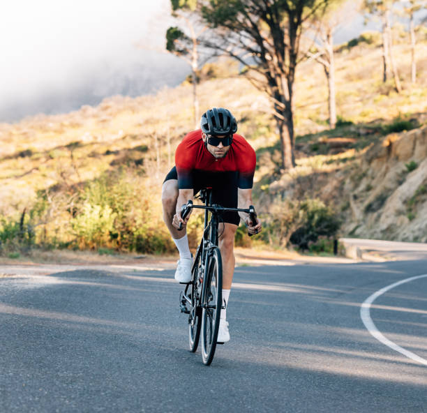istock Young athlete riding a bicycle on an empty road. Cyclist in helmet and goggles exercising outdoors. 1482433755