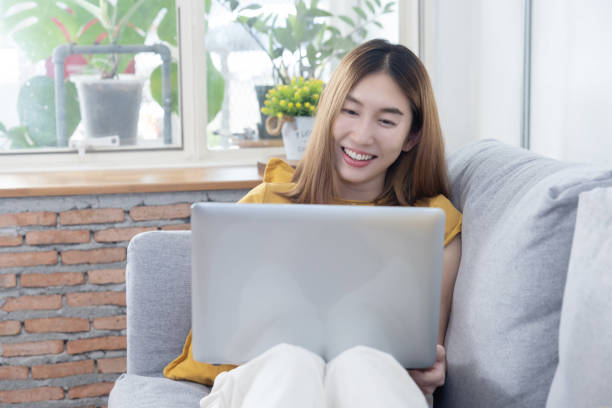 istock Asian Woman Using Laptop on Sofa 1482436180
