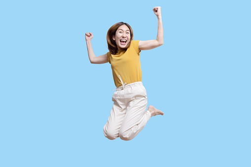 Isolated Asain Woman Jump into the Air with Smile on White Background