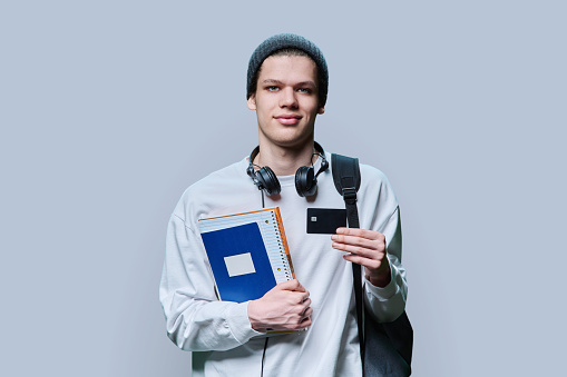 Young teenager boy holding Iceland passport looking positive and happy standing and smiling with a confident smile against white background.