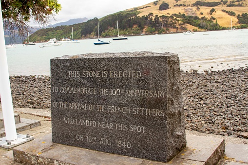 Monument stone to French settlers on waterfront of Akaroa, New Zealand.