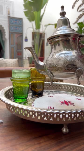 Pouring hot Moroccan mint tea into tea glass at Marrakech riad