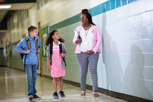 istock Pregnant teacher walking with students in school hallway 1482447222