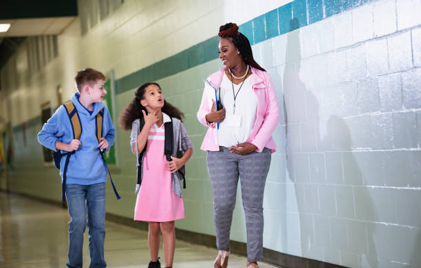 istock Pregnant teacher walking with students in school hallway 1482447227