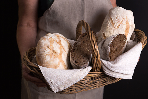 Woman holding basket with homemade bread.