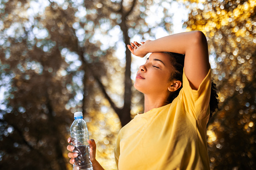 Athlete woman drinking water taking a break from running