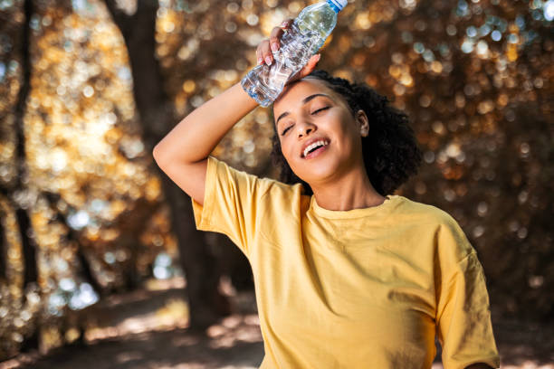 istock Smiling athlete woman drinking water taking a break 1482449523