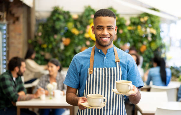 istock Happy waiter serving coffee at a cafe 1482449600