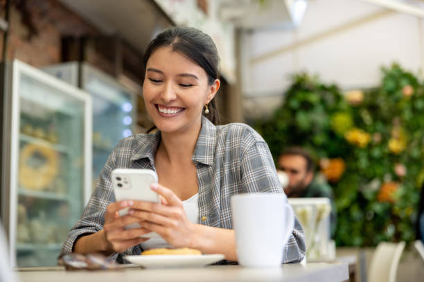 istock Happy woman at a cafe messaging on cell phone 1482449609