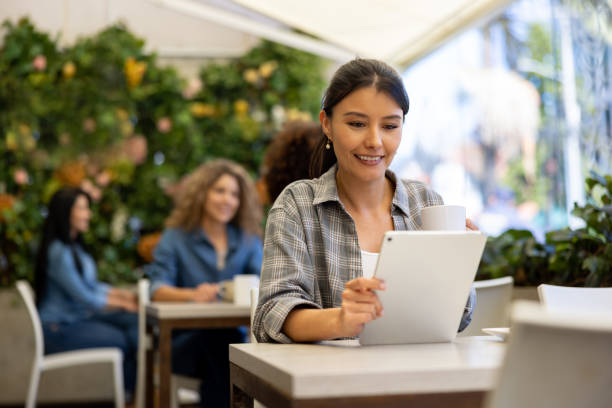 istock Woman reading on her tablet computer at a coffee shop 1482449612
