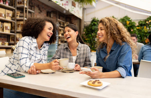 feliz grupo de mujeres divirtiéndose hablando en una cafetería - mobile phone coffee shop group of people women fotografías e imágenes de stock